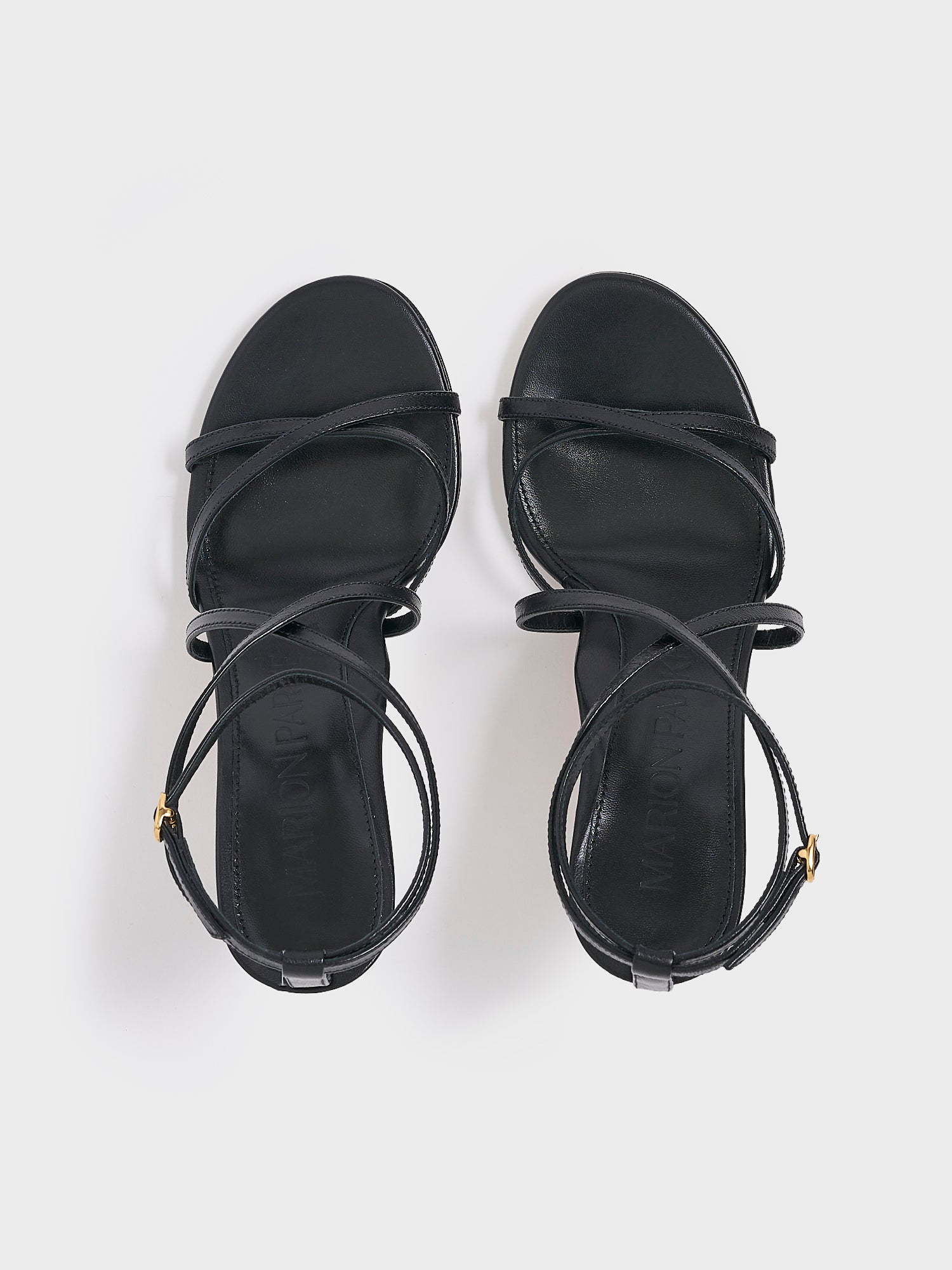 top view of a black leather high heel strappy sandal with an ankle strap detail. 