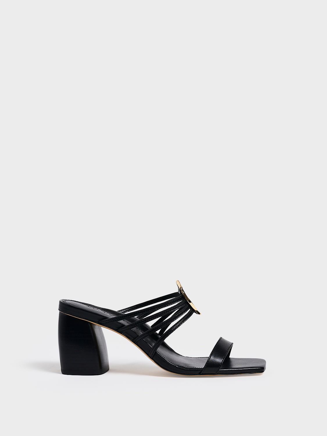 Profile view of a black leather block heel sandal with a strappy design and sculpted gold hardware.