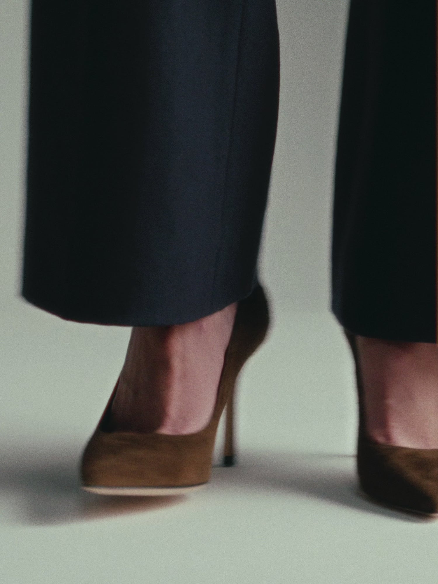 Chocolate suede pumps shown on a model. 